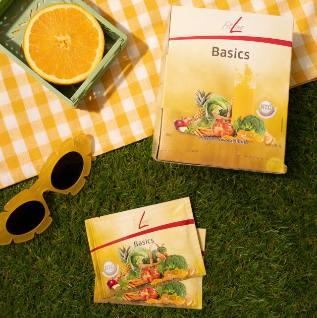 Packung Basics-Tabletten auf einem Holztisch, Tageslicht, geordnete ruhige Anordnung mit einer kleinen Schale daneben